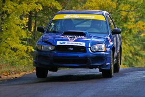 Kenny Bartram / Dennis Hotson catch minimal air at the midpoint jump on Brockway 1, SS13, in their Subaru WRX STi.