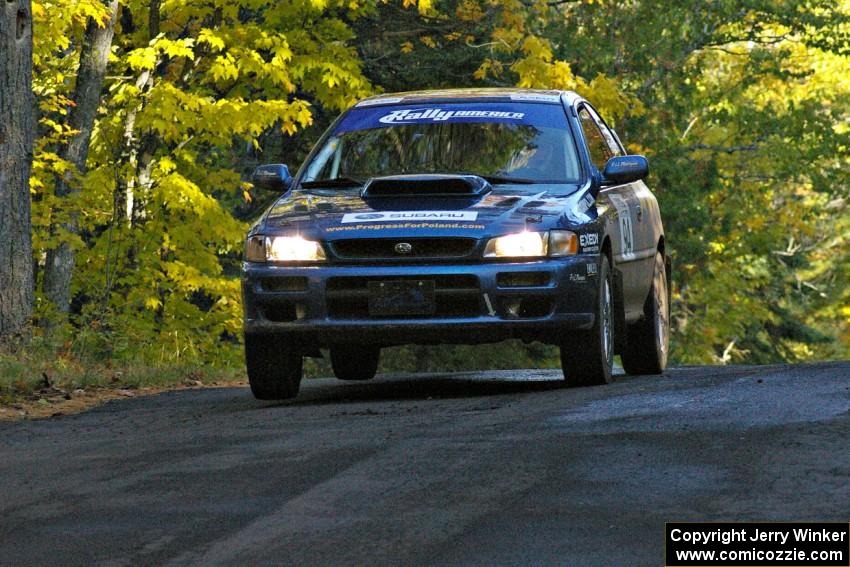 The Piotr Fetela / Dariusz Belzowski Subaru Impreza gets minimal air at the midpoint jump on Brockway 2, SS16.