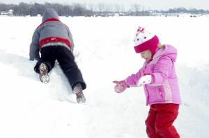 Kids playing on the snowbank on the lake access road.