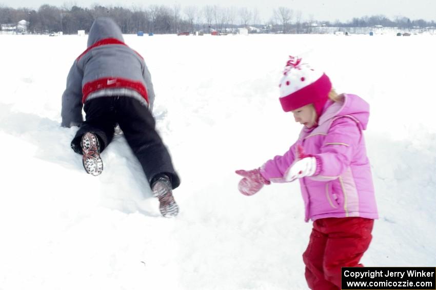 Kids playing on the snowbank on the lake access road.