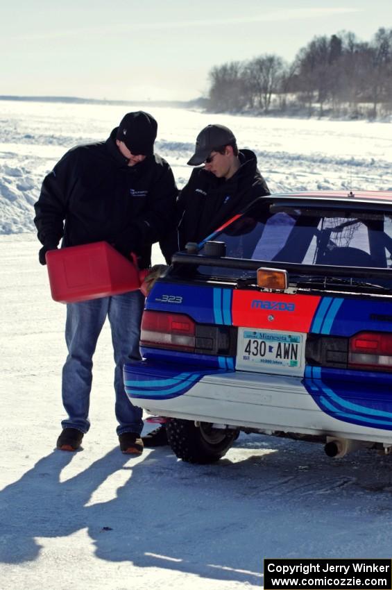 Chris Orr and Andy Orr fuel up their Mazda 323GTX.