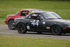 Greg Youngdahl ducks inside Paul Gilbert, both running Spec Miata Mazda Miatas.