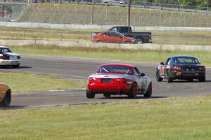 Bruce Andersen II leads Bruce Andersen through turn 4. Both were in Spec Miata Mazda Miatas.