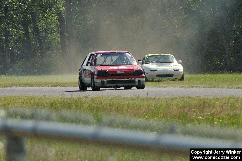 Dan Corgard's Spec Miata Mazda Miata returns to the track behind Mark Brakke's H Production Honda Civic.