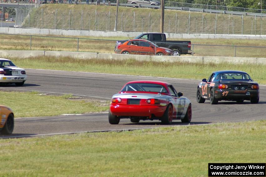 Bruce Andersen II leads Bruce Andersen through turn 4. Both were in Spec Miata Mazda Miatas.