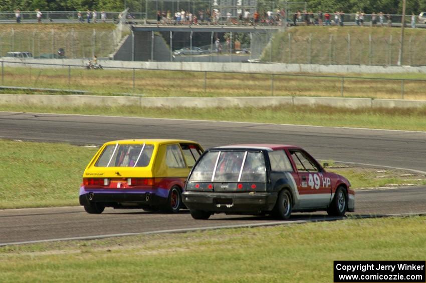 Jimmy Griggs's GTL VW Rabbit and Mark Brakke's H Production Honda Civic go side-by-side into turn 4.