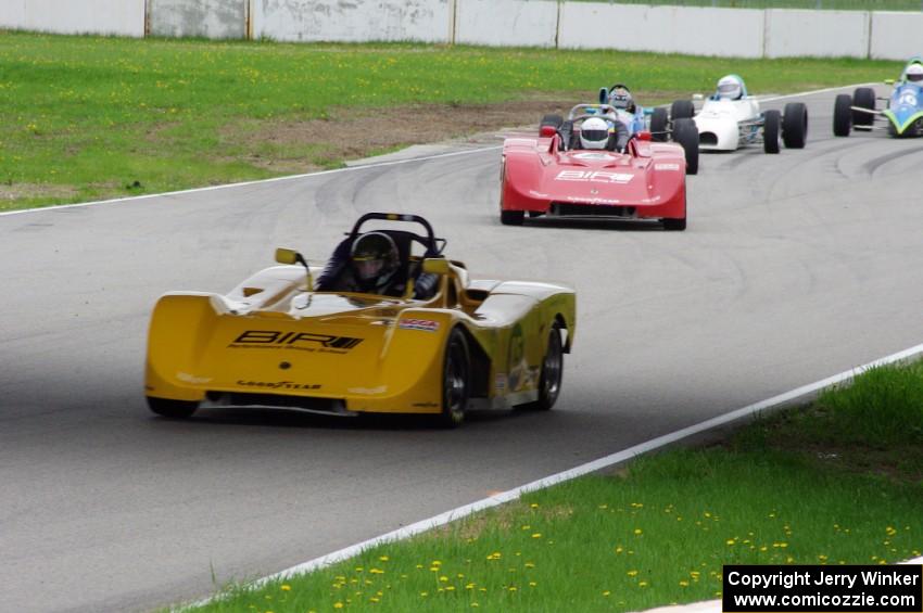 The Spec Racer Fords of Jed Copham and Dave Copham lead a pack of Formula Fords through turns 12 and 13