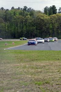 Derek Thorn's Ford Fusion leads the field into turn 4 on lap one.