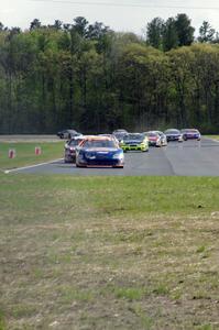 Derek Thorn's Ford Fusion leads the field into turn 4 on lap one.