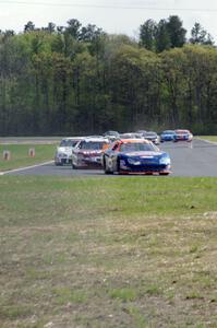 Derek Thorn's Ford Fusion leads the field into turn 4 on lap one.