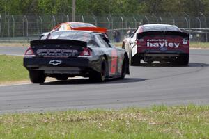 Derek Thorn's Ford Fusion ahead of Cameron Hayley's Ford Fusion and Michael Self's Chevy Impala.