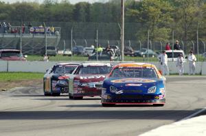 Derek Thorn's Ford Fusion ahead of Cameron Hayley's Ford Fusion and Michael Self's Chevy Impala.