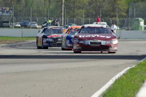 Cameron Hayley's Ford Fusion ahead of Derek Thorn's Ford Fusion while Michael Self's Chevy Impala follows.