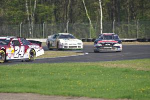 Cameron Hayley's Ford Fusion stays ahead of Michael Self's Chevy Impala and Andrew Ranger's Dodge Charger