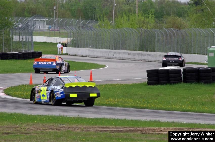 Michael Self's Chevy Impala ahead of Derek Thorn's Ford Fusion and Dallas Montes's Chevy Impala