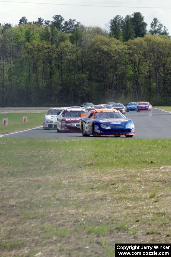 Derek Thorn's Ford Fusion leads the field into turn 4 on lap one.