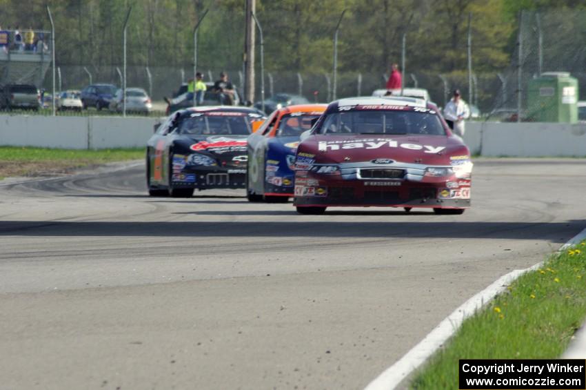 Cameron Hayley's Ford Fusion ahead of Derek Thorn's Ford Fusion while Michael Self's Chevy Impala follows.