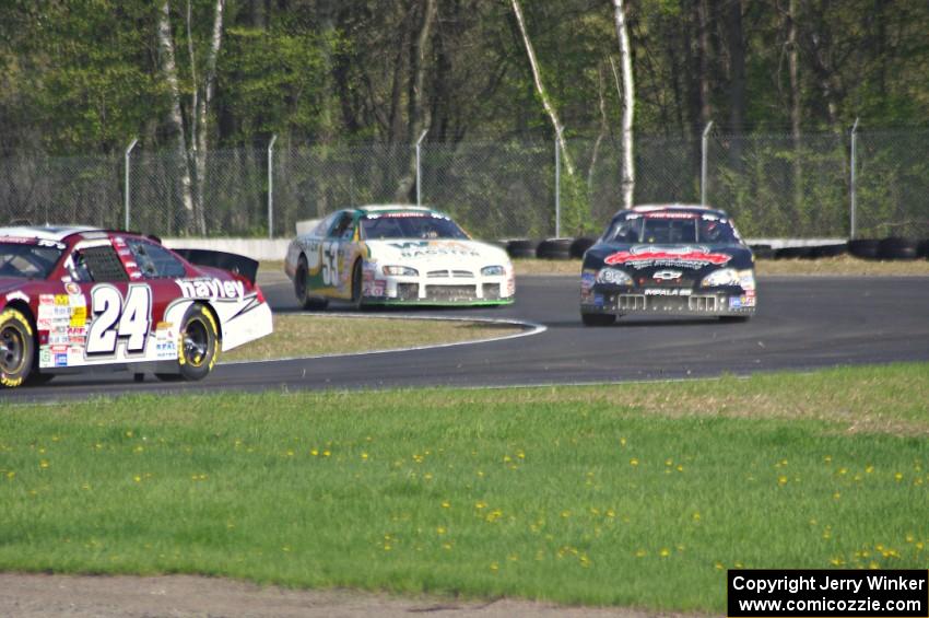 Cameron Hayley's Ford Fusion stays ahead of Michael Self's Chevy Impala and Andrew Ranger's Dodge Charger