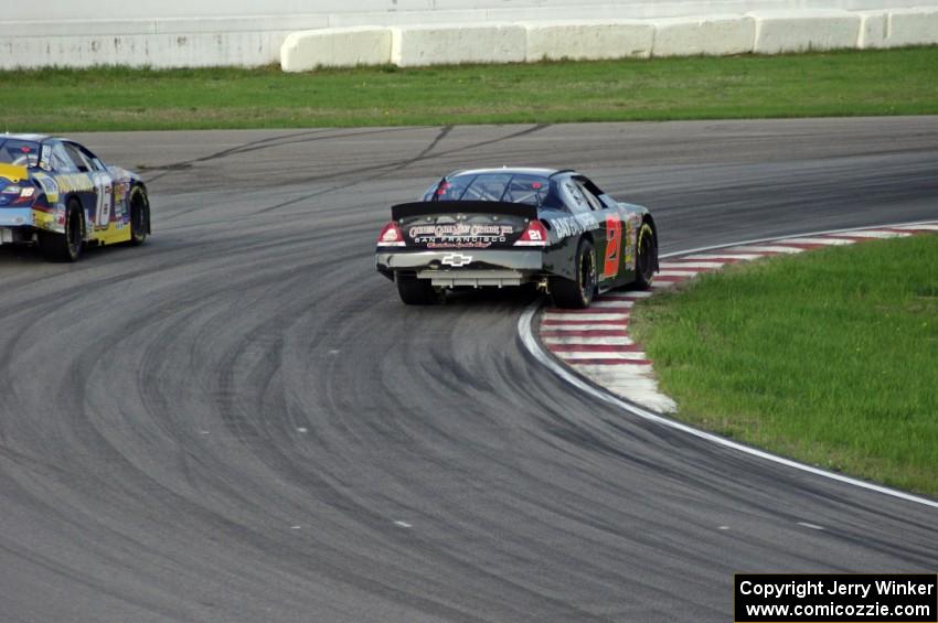 Michael Self's Chevy Impala passes Sergio Peña's Toyota Camry at turn 13.