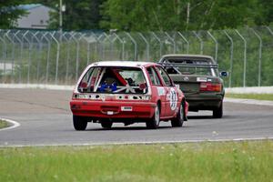 E30 Bombers BMW E30 and Team Party Cat Honda Civic go through turn 6.