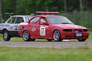 Flying Circus BMW E36 passes the North Star Chump Car - NSCC BMW 318i into turn 3.