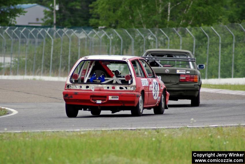 E30 Bombers BMW E30 and Team Party Cat Honda Civic go through turn 6.