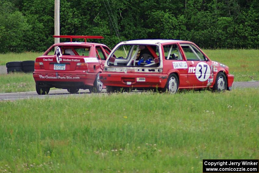 Team Party Cat Honda Civic loses power coming out of turn 4 as the Flying Circus BMW E36 passes by.