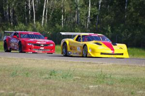 Tony Ave's Chevy Corvette passes Cameron Lawrence's Chevy Camaro into turn three.