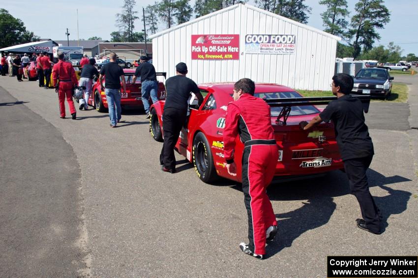 Pete Halsmer's Chevy Camaro and Cameron Lawrence's Chevy Camaro head into post-qualifying inspection.