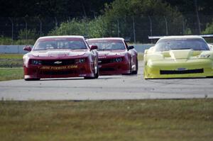 Doug Peterson's Chevy Corvette passes Bob Stretch's Chevy Camaro and Cameron Lawrence's Chevy Camaro