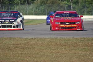 Bob Stretch's Chevy Camaro passes John Cottrell's Chevy Monte Carlo into turn 12,