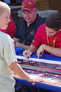 Cameron Lawrence signs an autograph for a young fan.