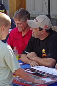 Pete Halsmer and Tony Ave sign autographs for a young fan.