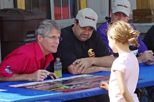 Pete Halsmer and Tony Ave sign autographs for a young fan.