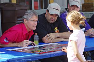 Pete Halsmer and Tony Ave sign autographs for a young fan.