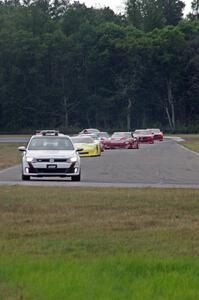 The field streams into turn four on the pace lap.