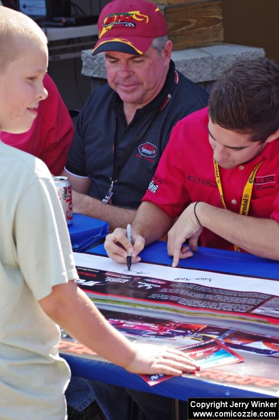 Cameron Lawrence signs an autograph for a young fan.