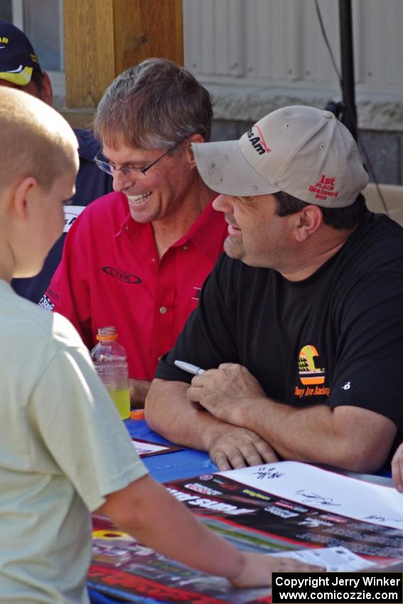 Pete Halsmer and Tony Ave sign autographs for a young fan.