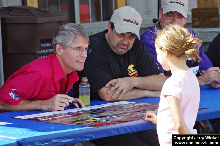Pete Halsmer and Tony Ave sign autographs for a young fan.