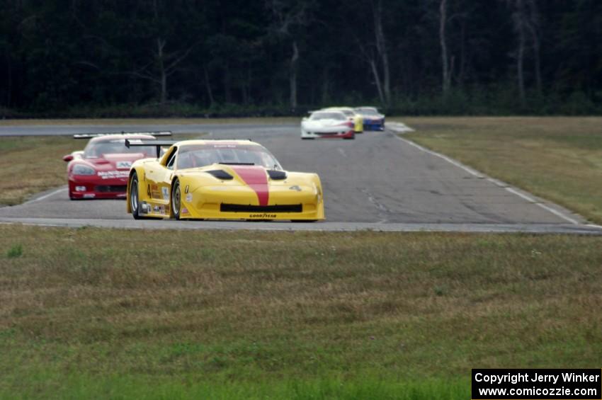 The field streams into turn four on lap two.