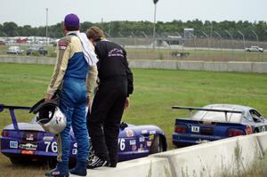 Chuck Cassaro and Matt Crandall watch the race from the concrete barrier at turn 4.