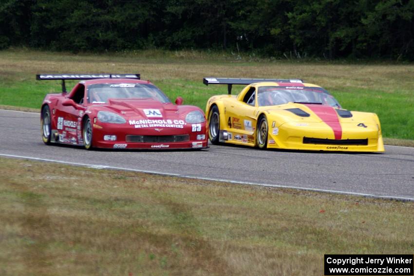 Tony Ave's Chevy Corvette and Amy Ruman's Chevy Corvette go side-by-side into turn 4.