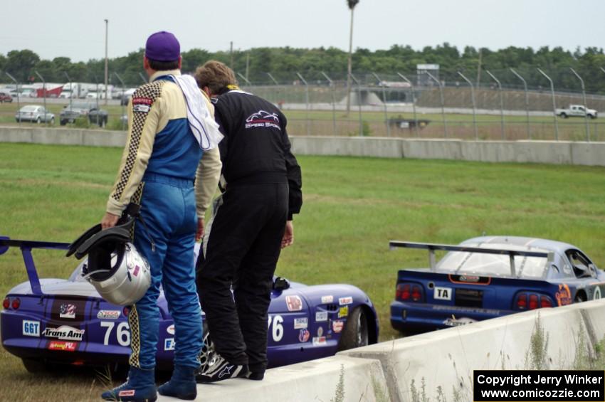 Chuck Cassaro and Matt Crandall watch the race from the concrete barrier at turn 4.