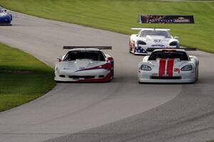 Simon Gregg's Chevy Corvette passes Kyle Kelly's Chevy Corvette as Dave Pintaric's Chevy Corvette follows