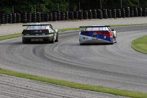 Simon Gregg's Chevy Corvette passes Gregg Rodgers's Chevy Camaro in the carousel