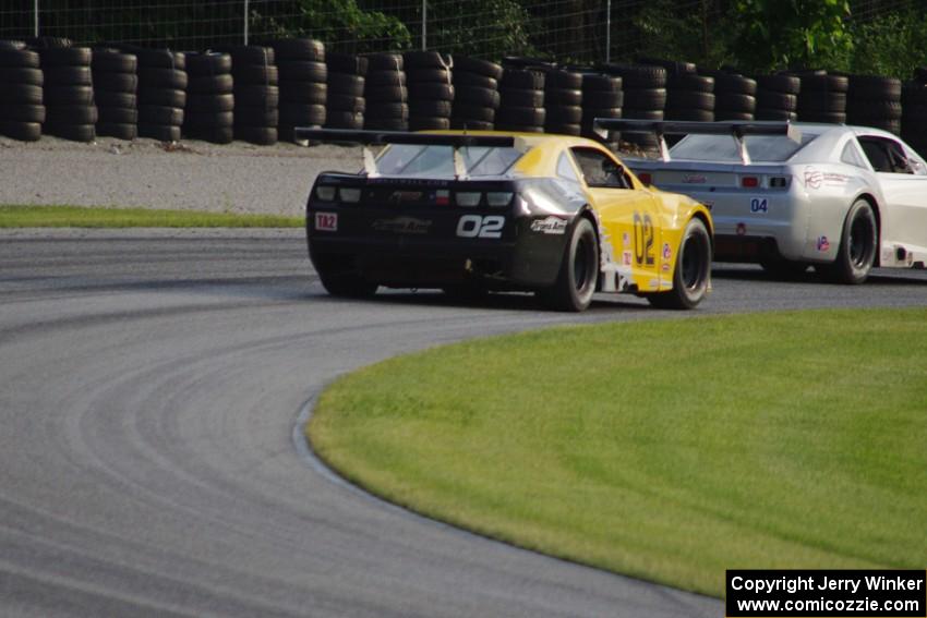 John Atwell's Chevy Camaro chases Kurt Roehrig's Chevy Camaro through the carousel