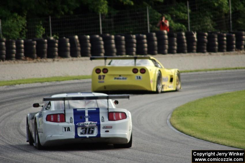 Cliff Ebben's Ford Mustang chases Doug Peterson's Chevy Corvette through the carousel