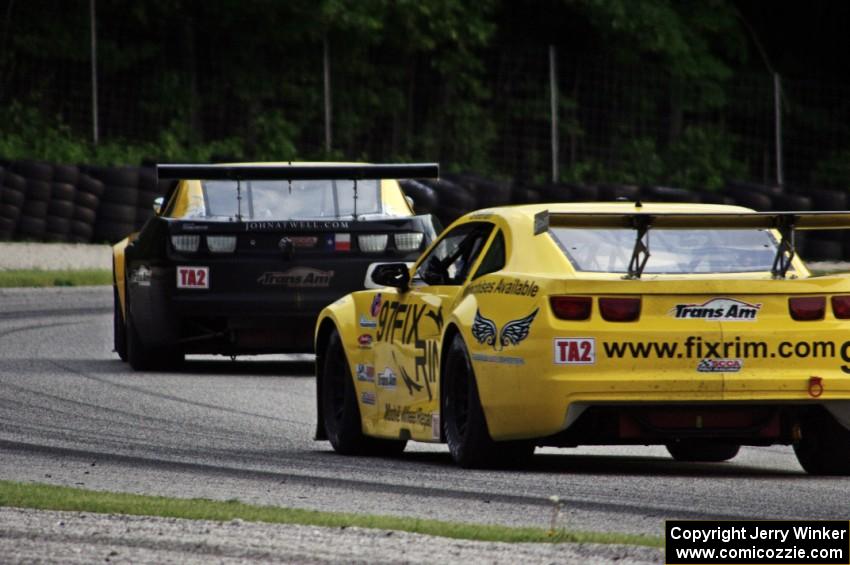 Tom Sheehan's Chevy Camaro chases John Atwell's Chevy Camaro through the carousel