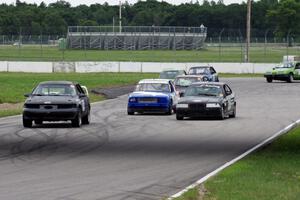 A gaggle of cars heads out of turn 12