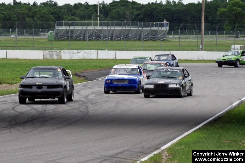 A gaggle of cars heads out of turn 12